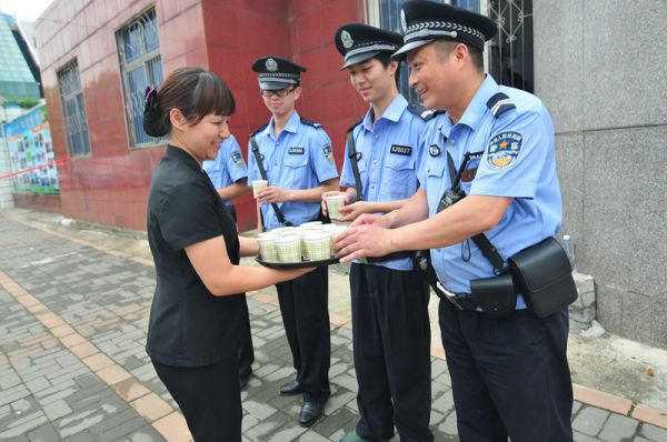 图为市民为龙山林（右一）和巡防队员送上绿豆汤。