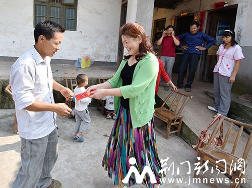 图二、爱心教师潘汉莲将功2000元捐款送到四胞胎父亲李帮军手中手。(董玉清摄影)