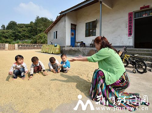 图四、爱心教师潘汉莲在栗溪山村四胞胎一起玩晒谷(董玉清摄影)