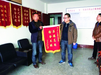 失主彭先生将一面锦旗送到人杰出租汽车公司。