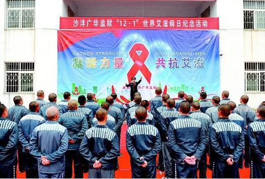 图为:昨日,广华监狱举行“12·1”世界艾滋病日纪念活动。图为监狱民警佩戴红丝带指挥服刑人员合唱。