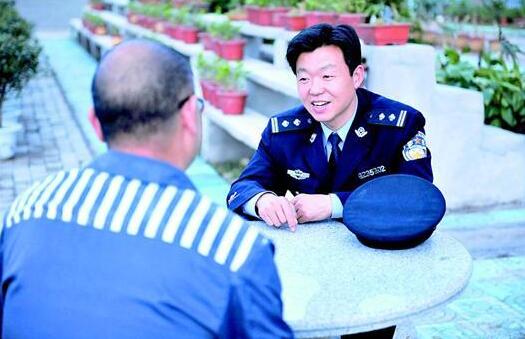 图为:监区长王文广与服刑人员进行谈话教育。