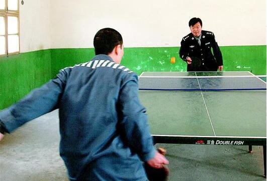图为:监区内,图书室、活动室一应俱全。图为民警与服刑人员打乒乓