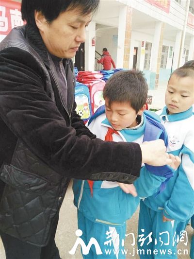 　　金跃亮给孩子们发放书包。