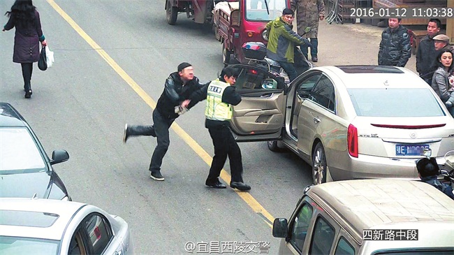 司机违法停车故意遮挡号牌，交警拍照取证