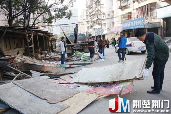 图为：正在拆除社区“三无”小区私搭乱建的简易房、店招店牌等