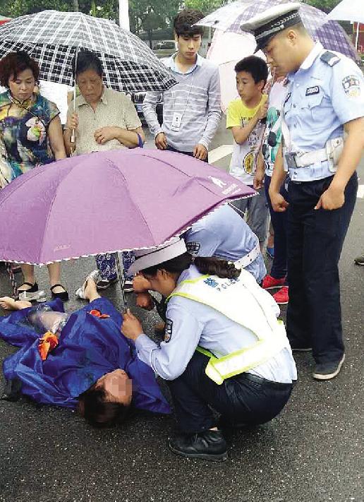 女子发病晕倒街头 女协警撑伞守护