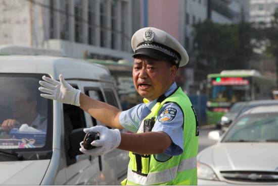 在烈日下疏导交通。