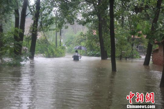 受灾的村民在齐胸深的水中前行 钟欣 摄