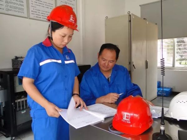 16日，陈鹏龙（右）在荆门东宝山油库查看健康、安全、环保管理台账。（中石化湖北荆门石油分公司  供图）.webp